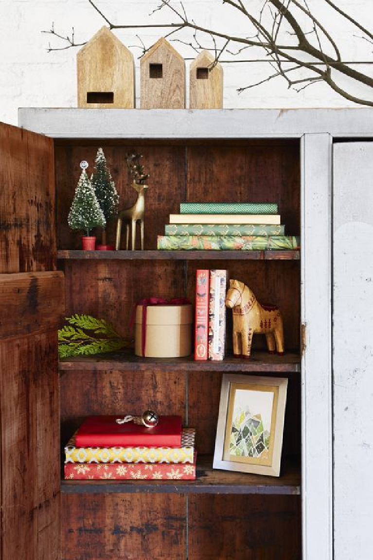 Farmhouse Christmas decorated shelves with bottle brush trees and Swedish dala horses.