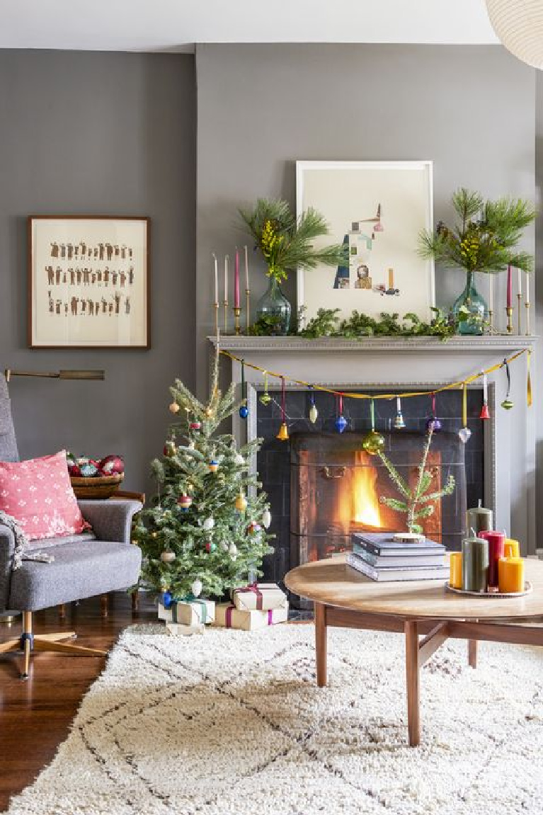 Casual living room with cheerful boho whimsical holiday decor and mini Christmas tree.