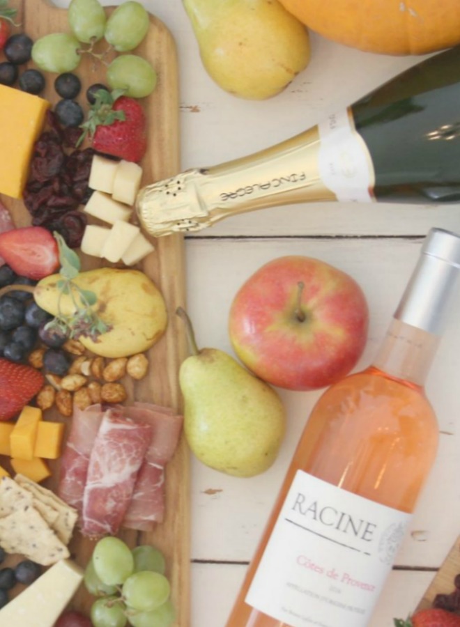 Vibrant colors for these easy to assemble graze boards (cheese boards!) with fruit, nuts, and wine - Hello Lovely Studio. #grazeboard #howto #cheeseboard #entertaining #cheese