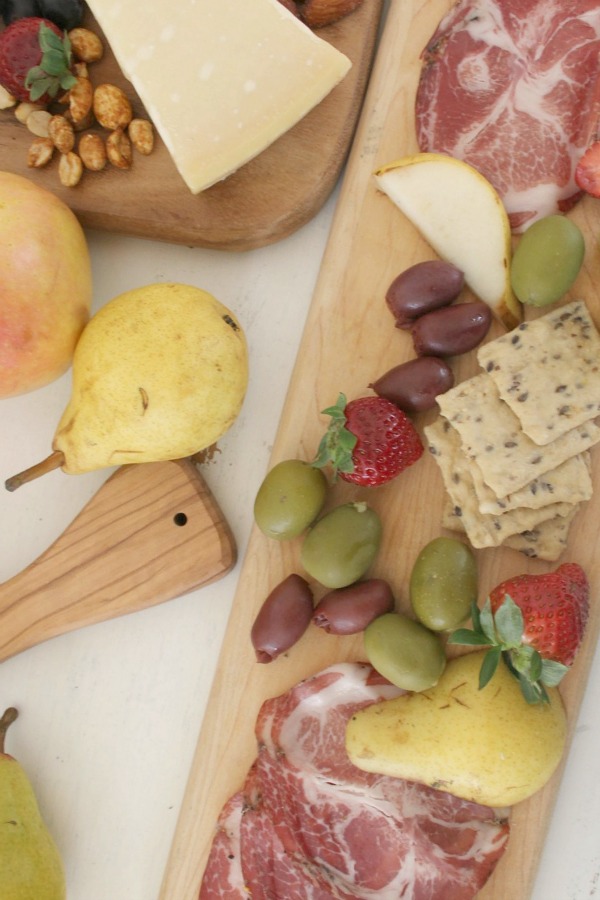 Vibrant colors for these easy to assemble graze boards (cheese boards!) with fruit, nuts, and wine - Hello Lovely Studio. #grazeboard #howto #cheeseboard #entertaining #cheese