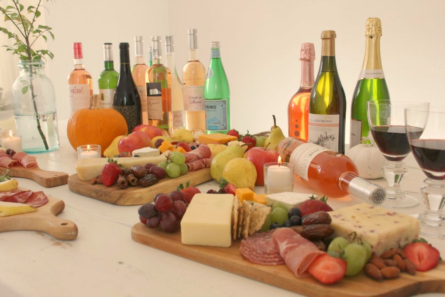 Vibrant colors for these easy to assemble graze boards (cheese boards!) with fruit, nuts, and wine - Hello Lovely Studio. #grazeboard #howto #cheeseboard #entertaining #cheese