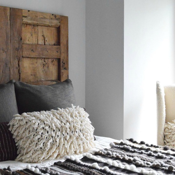 Rustic yet refined bedroom design with vintage wood door in lieu of headboard. Design by Michael del Piero. #bedroomdesign #rusticdesign #timelessdesign #interiordesign #headboard