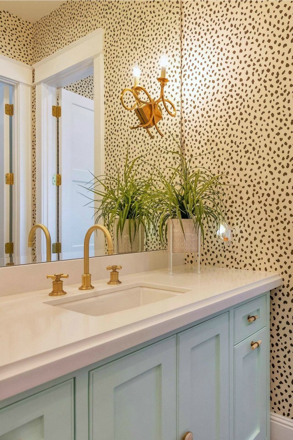 Whimsical wallpaper in a contemporary bath with brass hardware. #bathroomdesign #wallpaper #brasshardware