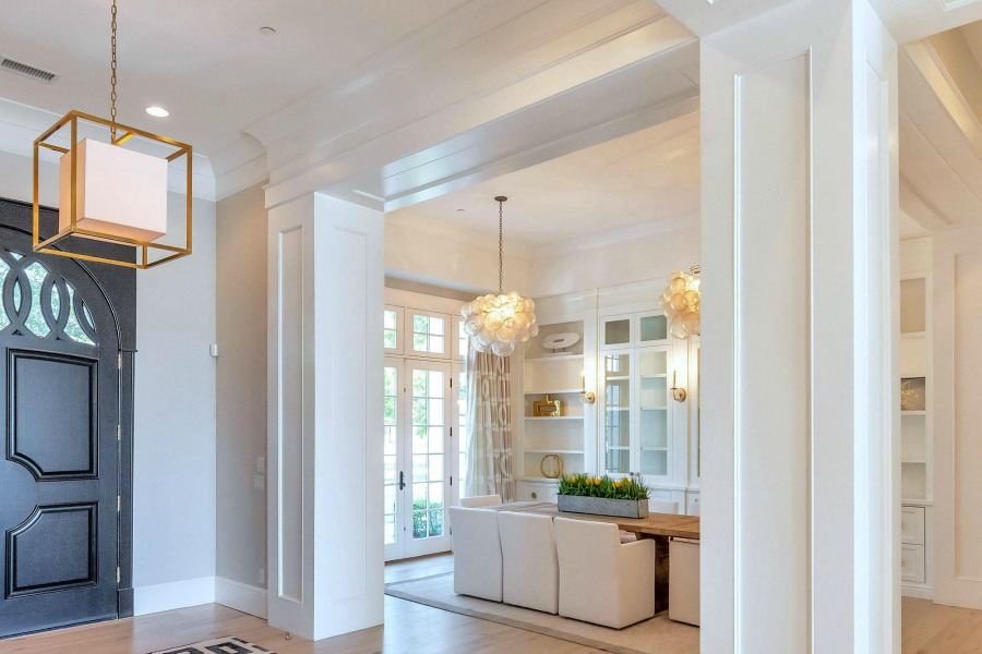 Modern French interior design in a dining room with contemporary pendants, built-ins, and a rustic dining table. #modernfrench #interiordesign #diningroom #builtins