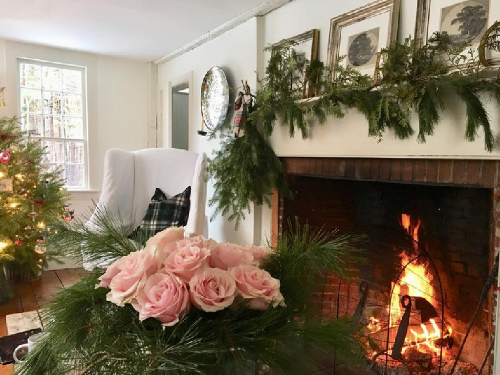 Nora Murphy's charming farmhouse living room with fireplace decorated for Christmas.