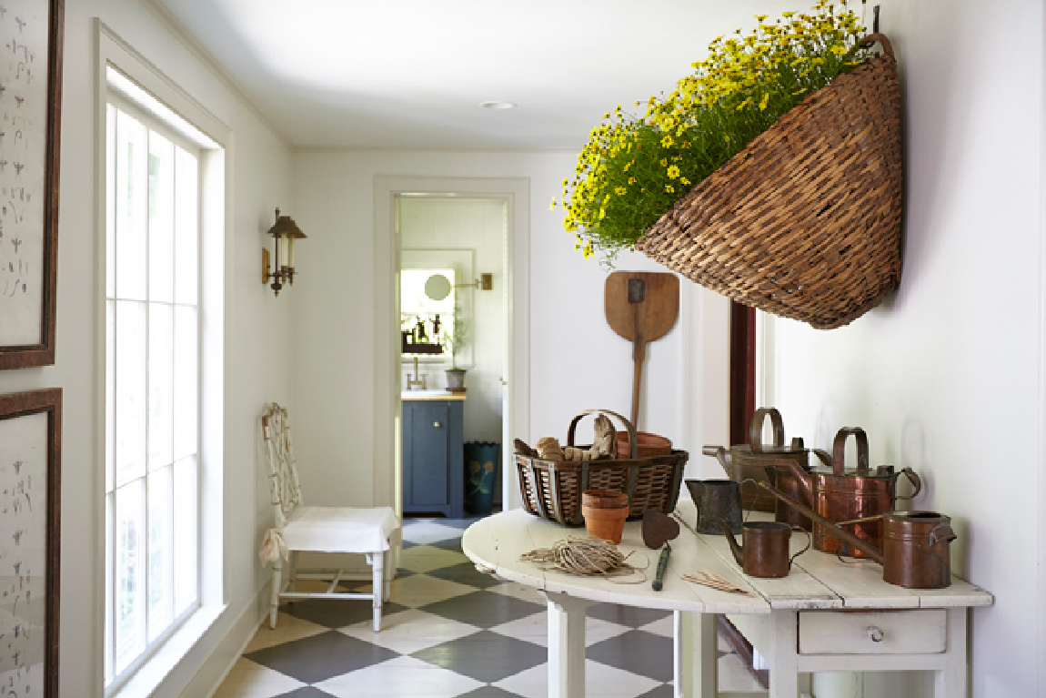 Nora Murphy's charming Connecticut farmhouse gallery with huge basket full of yellow flowers on wall.