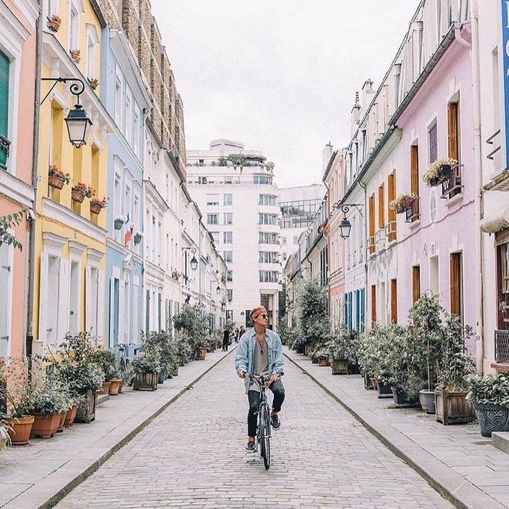 Paris pastels in fall offer a breathtaking design moment with these pretty facades on a street in Paris! @Travelmindset #parisinfall #parispastels #romantichomes #houseexteriors #pastels #autumn