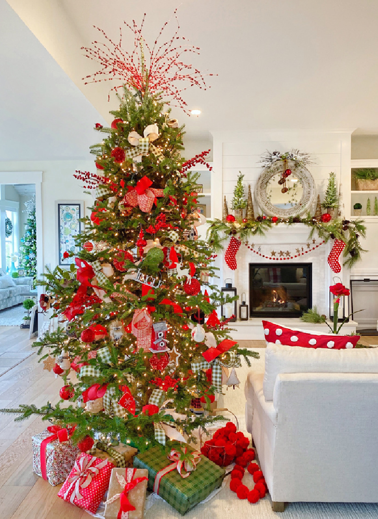 Vivid red accents on a cheerful Christmas tree in a whimsical family room decorated festively for the holidays - PlaidsandPoppies.