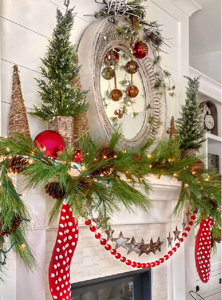 Merry and bright Christmas fireplace mantel decorated with red polka dot stockings and whimsical trees and greenery - Plaidsandpoppies.