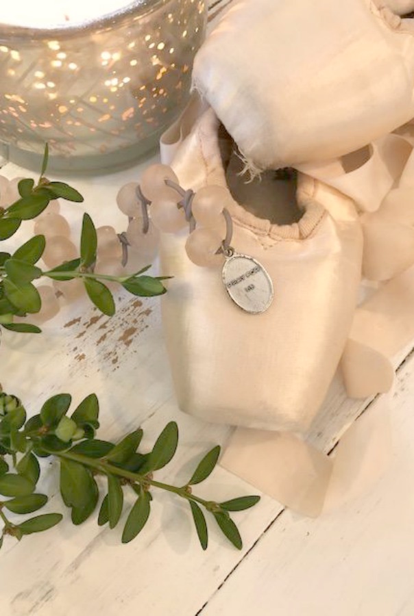 Pale pink pointe shoes ballet slippers, boxwood, and pink glass African beads.