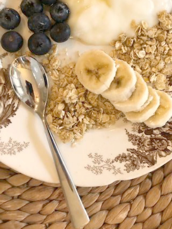 Brown transferware plate with yogurt, granola, and fruit.