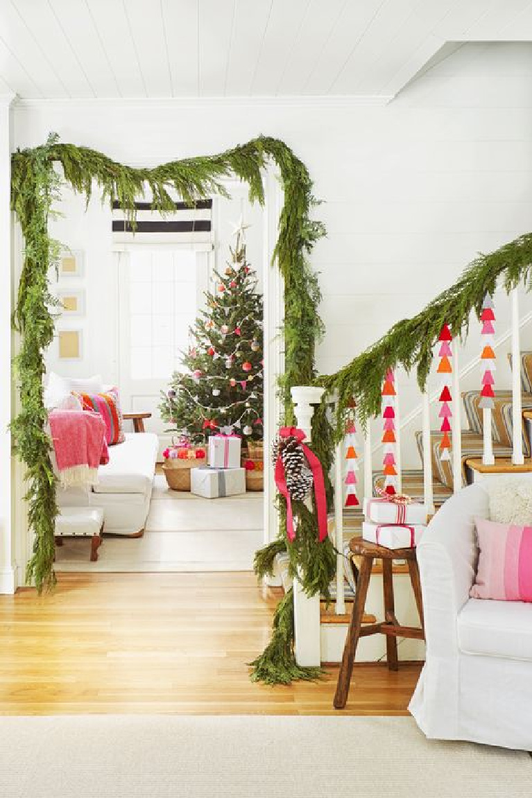 Darling pink Christmas decor accents with fresh greenery in an all white entry and living room with cottage style. #whimsicalchristmas #christmasdecor #shabbychic #countrychristmas