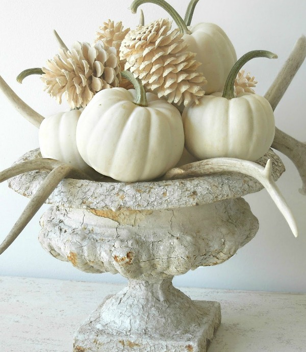 Gorgeous white fall centerpiece with white pumpkins, bleached pinecones, antlers and an old crusty urn - design by Tone on Tone. ##whitepumpkins #babyboo #centerpiece #fallarrangement #tablescape #thanskgiving #centerpiece