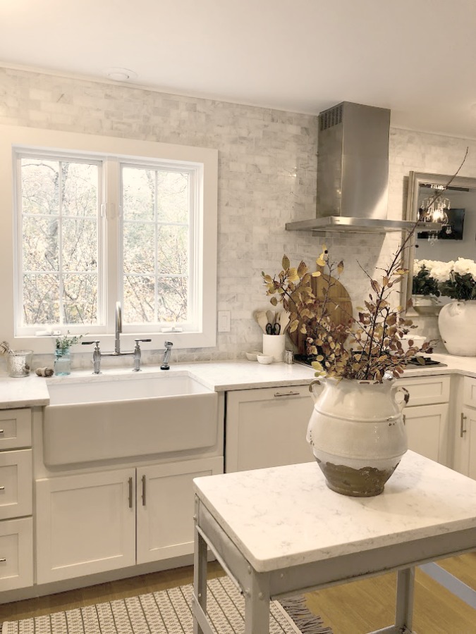 Shaker style white cabinets in simple serene kitchen with white oak floors and Viatera Minuet quartz countertops - Hello Lovely Studio.