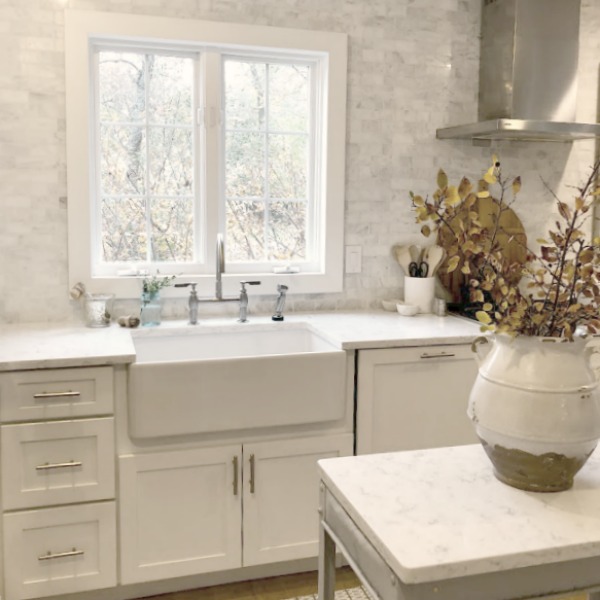 Shaker style white cabinets in simple serene kitchen with white oak floors and Viatera Minuet quartz countertops - Hello Lovely Studio.