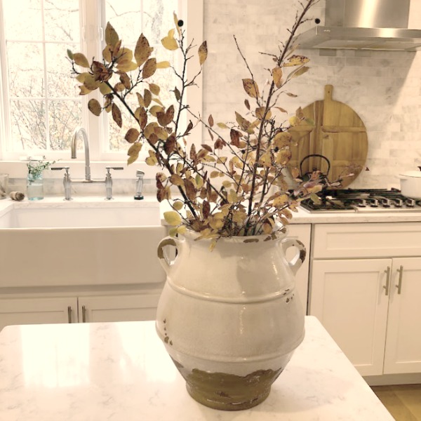 Shaker style white cabinets in simple serene kitchen with white oak floors and Viatera Minuet quartz countertops - Hello Lovely Studio.