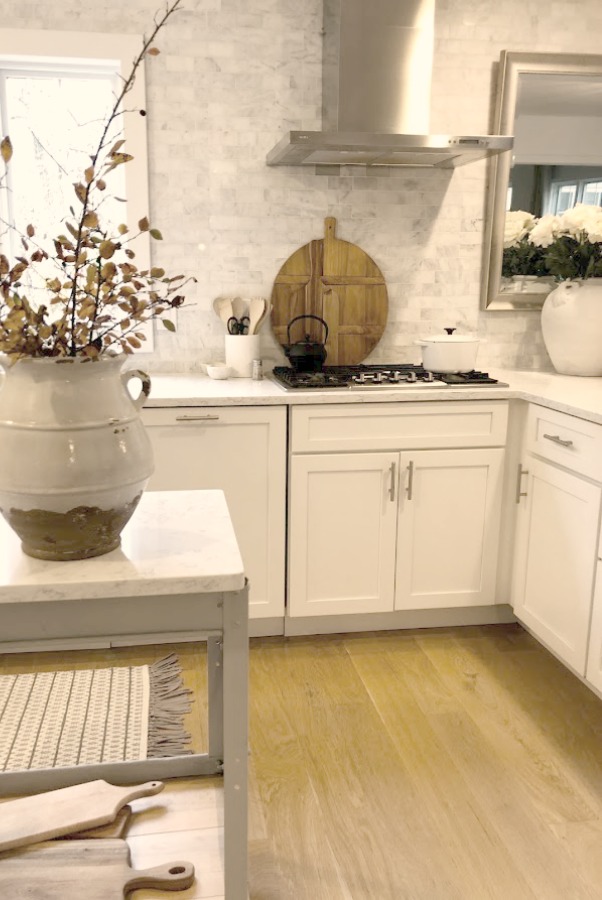 Shaker style white cabinets in simple serene kitchen with white oak floors and Viatera Minuet quartz countertops - Hello Lovely Studio.