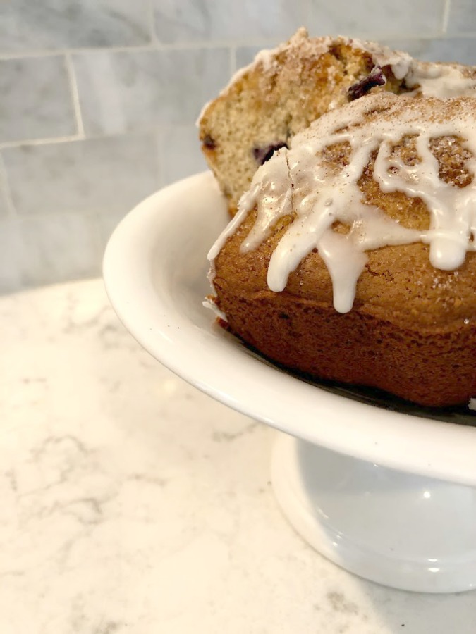 Coffee cake on a white vintage cake pedestal from Belgium on my Viatera Minuet quartz countertop in the kitchen - Hello Lovely Studio.