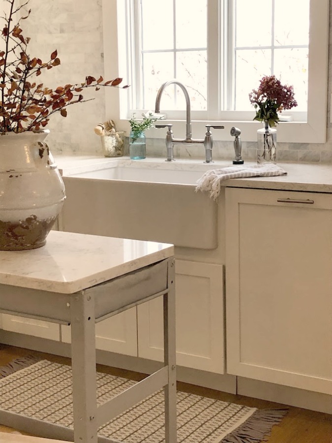 Shaker style white cabinets in simple serene kitchen with white oak floors and Viatera Minuet quartz countertops - Hello Lovely Studio.