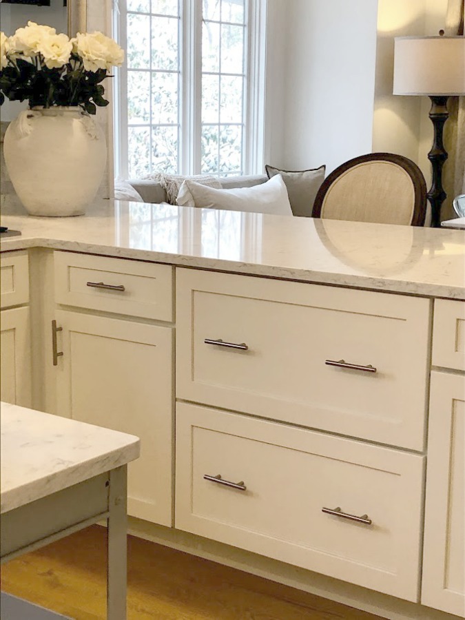 Shaker style white cabinets in simple serene kitchen with white oak floors and Viatera Minuet quartz countertops - Hello Lovely Studio.