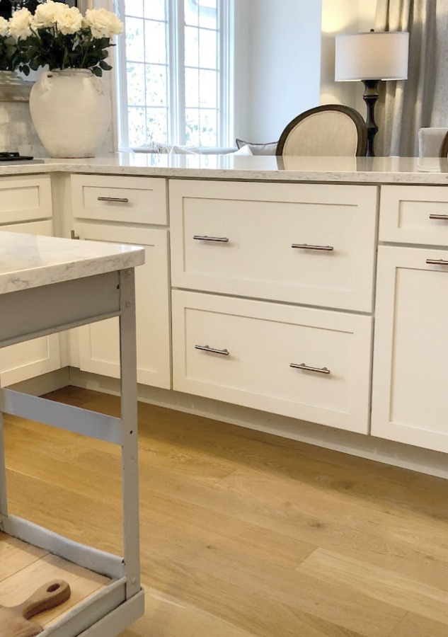 Shaker style white cabinets in simple serene kitchen with white oak floors and Viatera Minuet quartz countertops - Hello Lovely Studio.