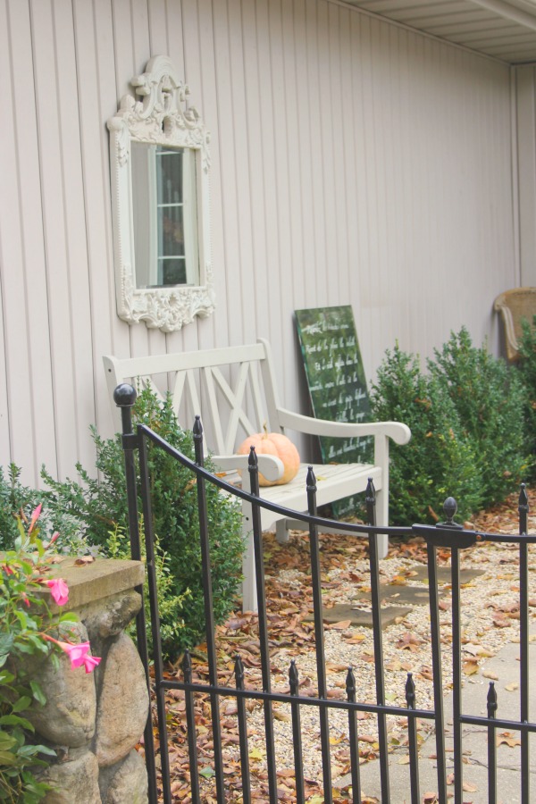 My French inspired courtyard in fall with autumn fallen leaves and boxwood - Hello Lovely Studio.