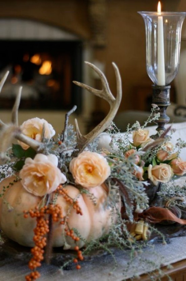 Pumpkin centerpiece with flowers and antlers stars in this Thanksgiving table setting idea. ##thanksgiving #tablescape #pumpkincenterpiece #falltable