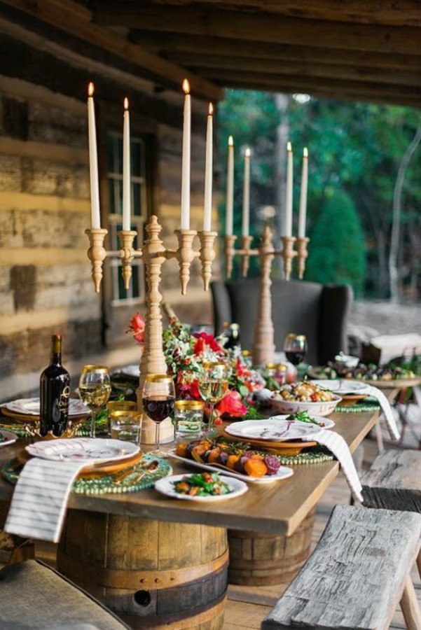 Enchanting outdoor fall table setting idea with wine barrel base table, candelabra, and romantic decor. #falltable #thanksgiving #tabledecor #tablsetting #tablescape #outdoordining