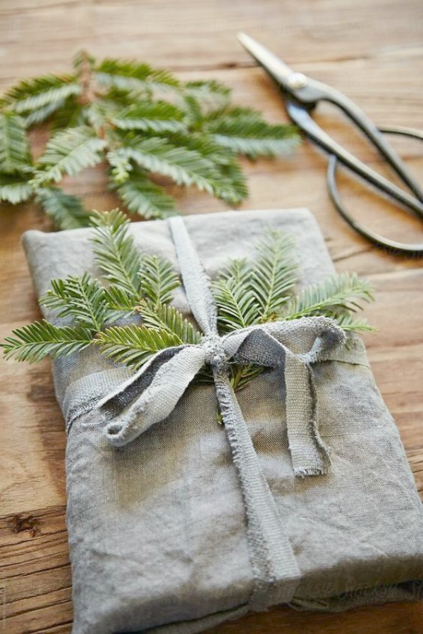 Rustic farmhouse Christmas decor idea with a linen wrapped gift with fresh evergreens - Clem Around the Corner. #christmasdecor #simplechristmas #farmhousechristmas #giftwrap