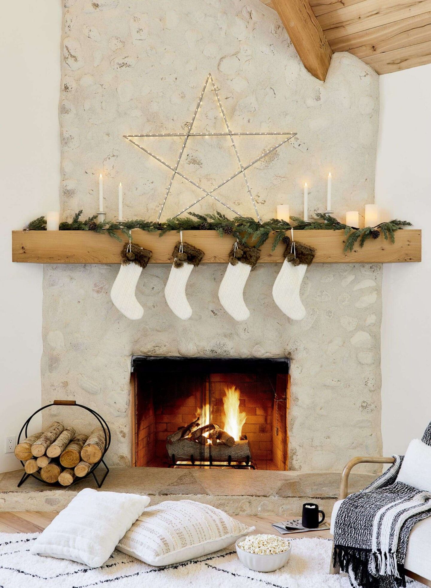 Neutral winter holiday decor in Emily Henderson's living room with stone fireplace. #holidaydecor #christmasdecor #fireplace #stockings