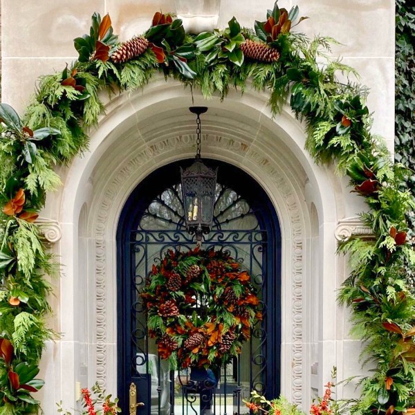 Magnificent French Christmas arched door embellished with at a beautiful chateau in New York - The Enchanted Home. #christmasdecor #elegantdecor #theenchantedhome #frenchchateau #frenchchristmas