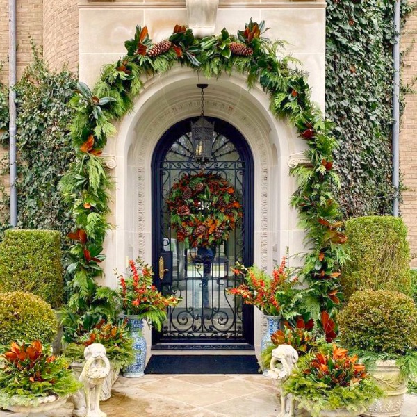 Magnificent French Christmas arched door embellished with at a beautiful chateau in New York - The Enchanted Home. #christmasdecor #elegantdecor #theenchantedhome #frenchchateau #frenchchristmas