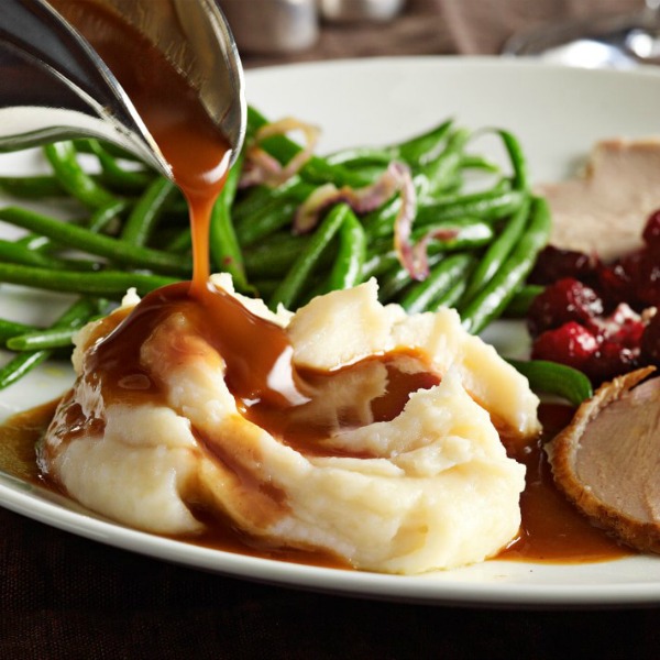 Delicious gravy poured over Thanksgiving mashed potatoes - Williams Sonoma. #mashedpotatoes #gravy #thanksgivingtable