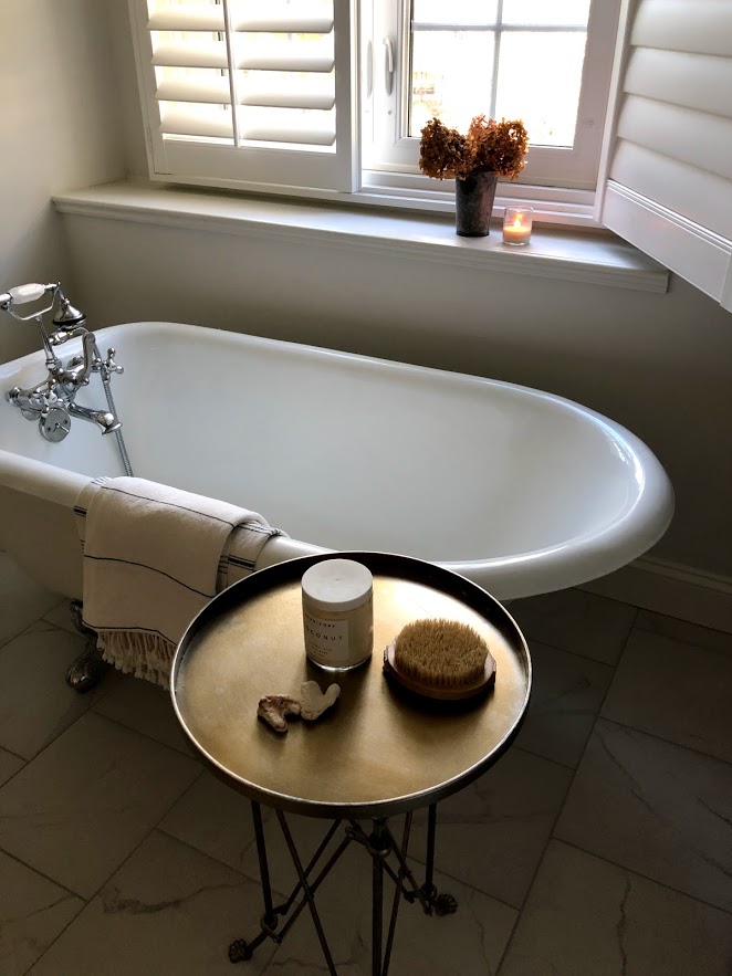 Clawfoot tub in a serene white bathroom by Hello Lovely Studio.