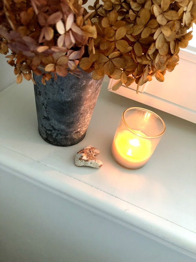 Dried hydrangea in zinc vase with candle in window sill - Hello Lovely Studio.