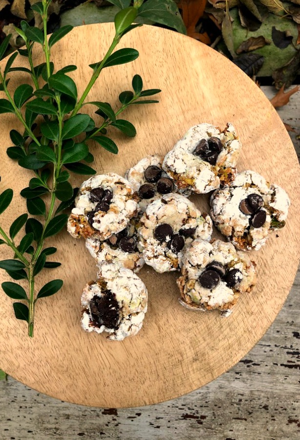 Pistachio Almond Crinkle Cookies on a Wood Pedestal - Hello Lovely Studio. #hellolovelystudio #cookierecipe #pistachio
