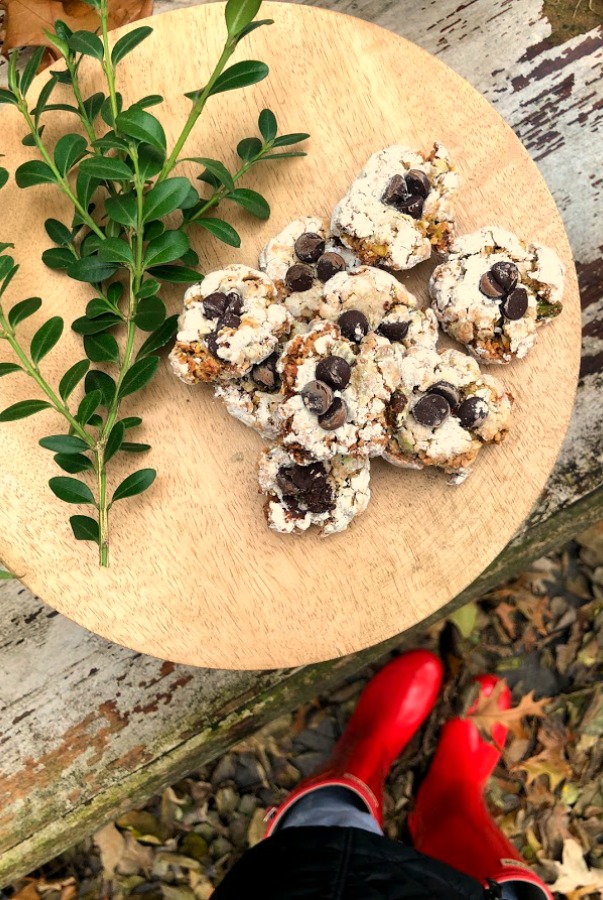 Pistachio Almond Crinkle Cookies on a Wood Pedestal - Hello Lovely Studio. #hellolovelystudio #cookierecipe #pistachio