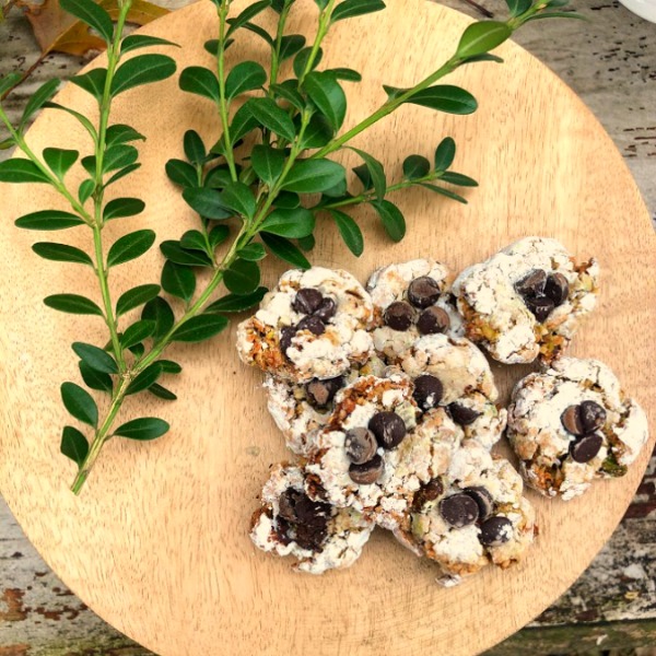 Pistachio Almond Crinkle Cookies on a Wood Pedestal - Hello Lovely Studio. #hellolovelystudio #cookierecipe #pistachio