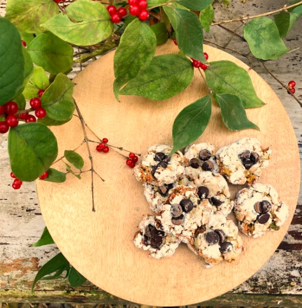 Pistachio Almond Crinkle Cookies on a Wood Pedestal - Hello Lovely Studio. #hellolovelystudio #cookierecipe #pistachio