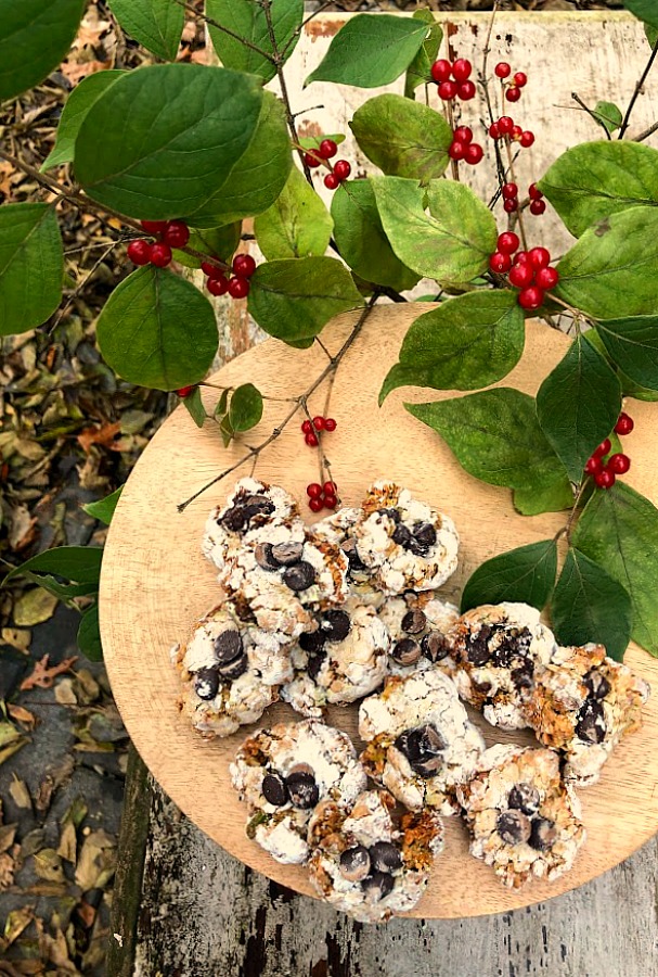 Pistachio Almond Crinkle Cookies on a Wood Pedestal - Hello Lovely Studio. #hellolovelystudio #cookierecipe #pistachio