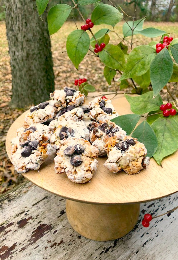 Pistachio Almond Crinkle Cookies on a Wood Pedestal - Hello Lovely Studio. #hellolovelystudio #cookierecipe #pistachio