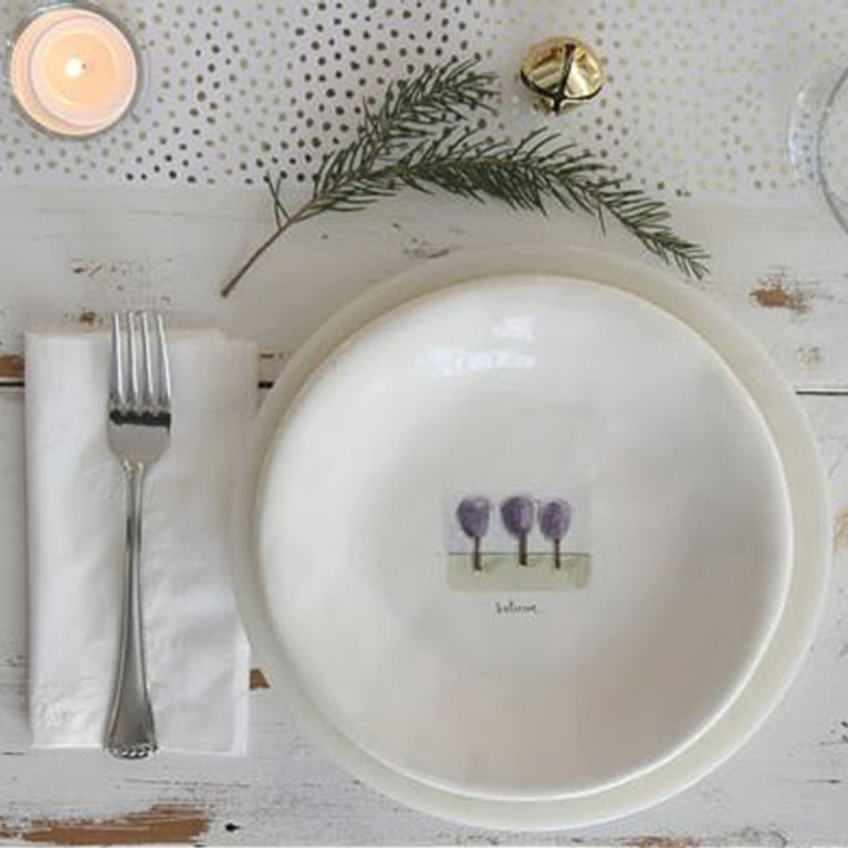 Simple serene holiday placesetting with white Rae Dunn plates and farm table - Hello Lovely Studio. #placesetting #holidaytable #holidaydinner #farmhousechristmas