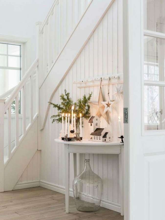 Gorgeous Scandinavian white Christmas decorating in a white cottage style entry with candlelight - Lantliv.