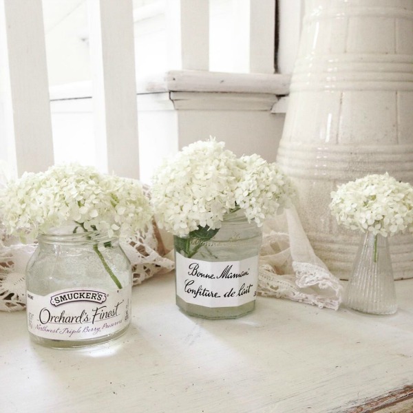 White hydrangea in jam jars in an all white Nordic cottage by My Petite Maison.