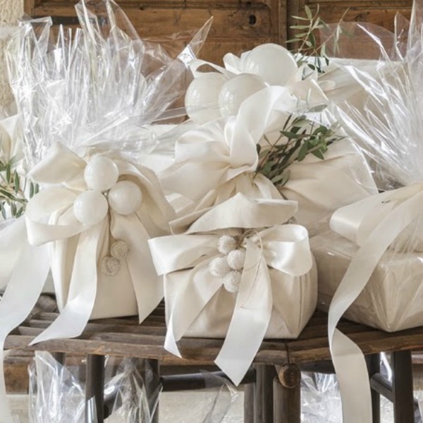 Pamela Pierce Christmas decorated home. Gifts are wrapped in silk chamois and suede cloth. Then the packages are finished with cellophane to create a shimmery sparkle and accented with fresh sprigs from olive branches.