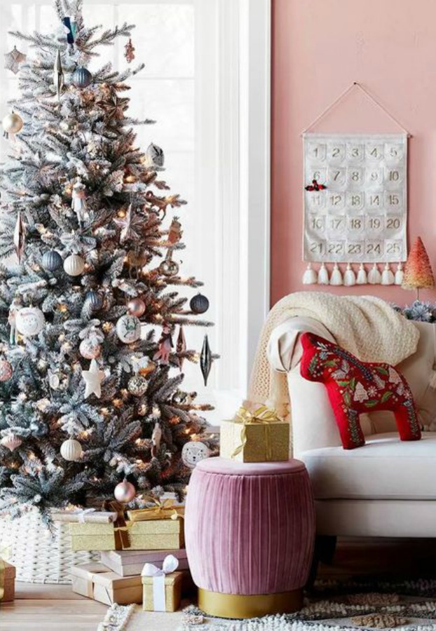 Pink Christmas inspiration with pink wall and rose/gold bottle brush tree as well as a pink ottoman - Target.