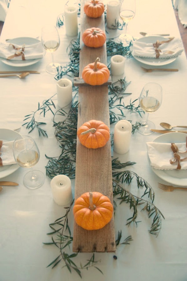 Simple lovely fall table Thanksiving tablescape idea with long wood board and mini pumpkins - Gwen Moss. #falltable #tabledecor #thanksgiving #tablescape