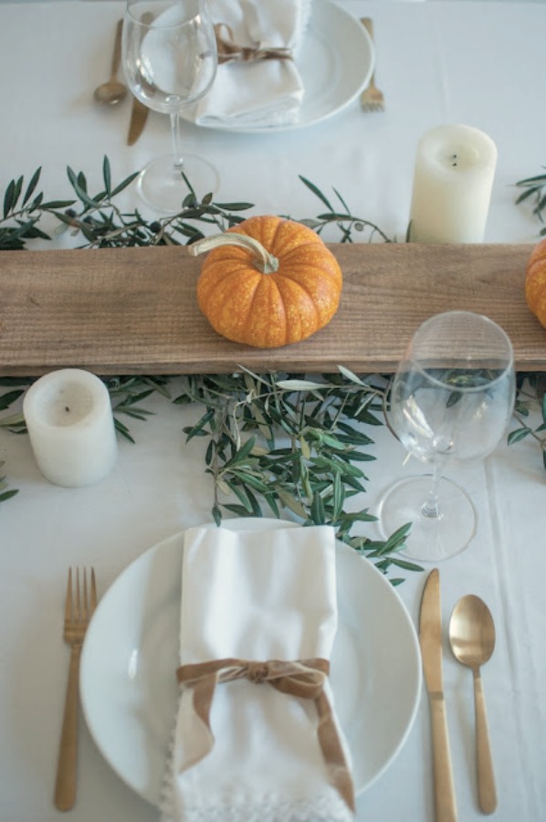 Simple lovely fall table Thanksiving tablescape idea with long wood board and mini pumpkins - Gwen Moss. #falltable #tabledecor #thanksgiving #tablescape