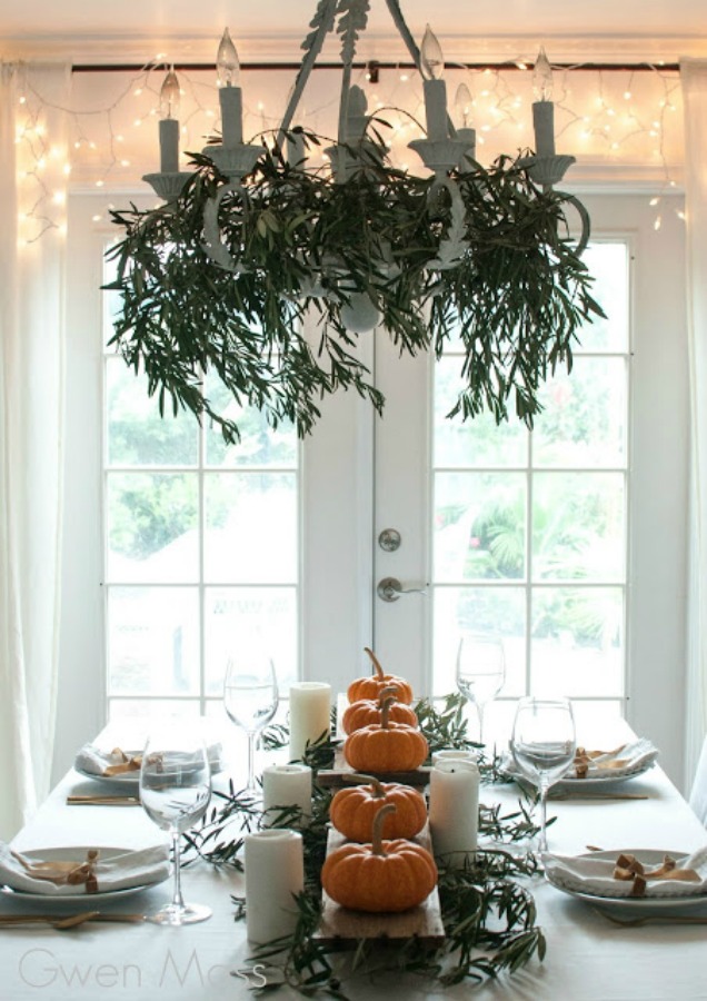 Beautifully simple and Scandinavian inspired, this simple fall tablescape and Thanksgiving place setting idea with little pumpkins and fairy lights calms the mood! Gwen Moss. #falltable #tablescape #thanksgiving #tablesetting #placesetting #Scandinavianstyle