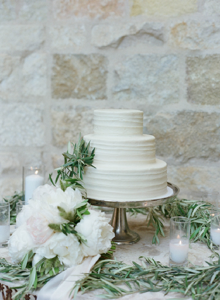 Elegant understated three tier wedding cake with natural florals and greenery against a warm stone backdrop at Sunstone Winery - photo by Elizabeth Messina. #weddingcakes #simplelegance #weddingideas #wineryweddings